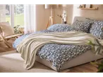 Dormitor luminos cu lenjerie de pat LIVARNO home din bumbac întărit, cu model floral albastru.