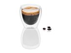 Double-walled glass espresso cup with coffee and beans.