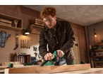 Man using a Parkside® 750W Electric Planer on wood in a workshop.