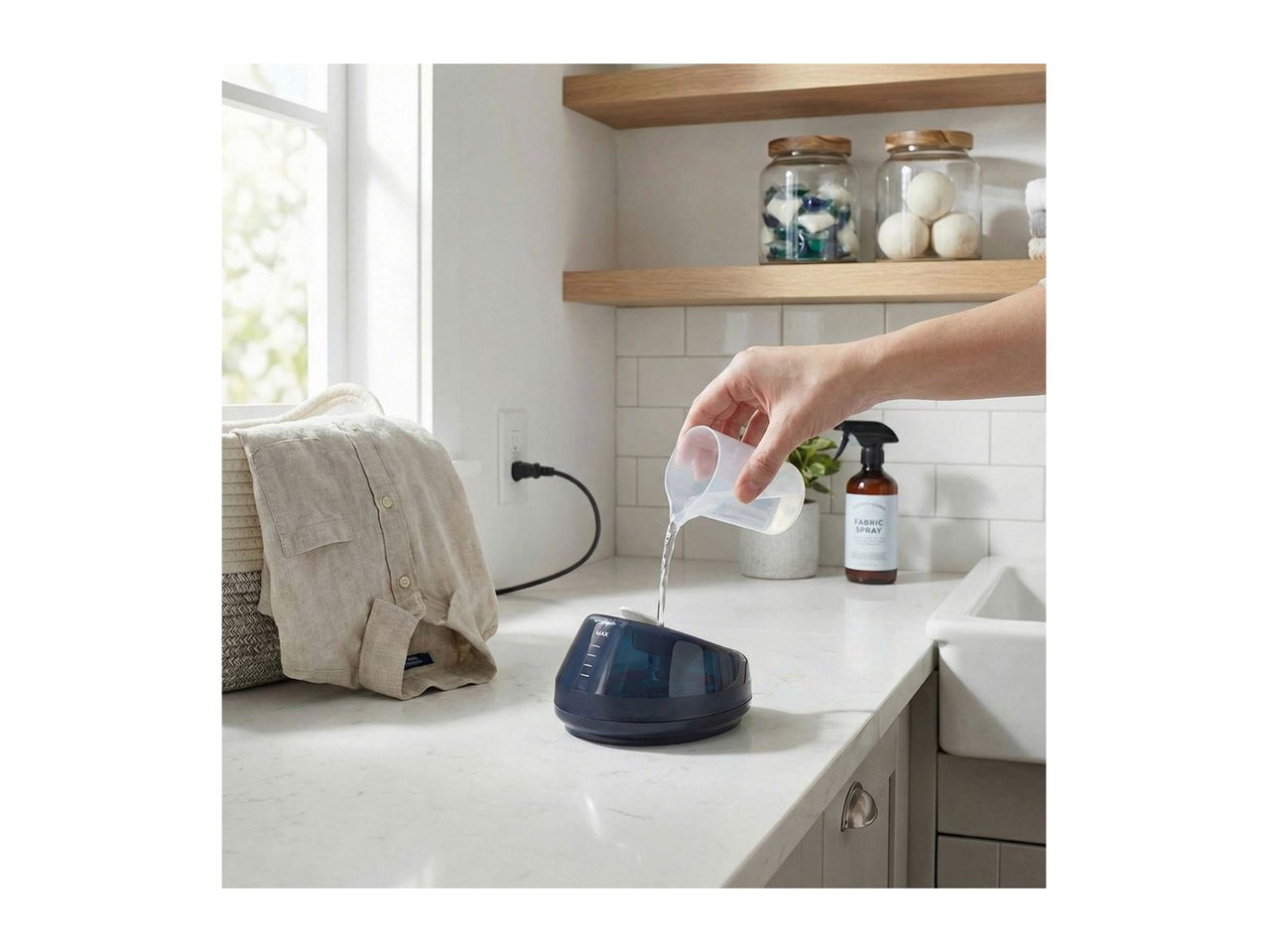 Person pouring water into a garment steamer on a countertop next to a laundry basket.