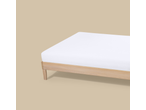 Livarno Jersey Fitted Sheet on a wooden bed frame, light beige background.
