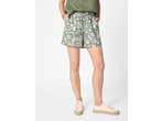 Woman wearing green floral shorts, a green top, and beige espadrille sneakers.