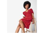 A model wears a red, short-sleeved, tiered dress.