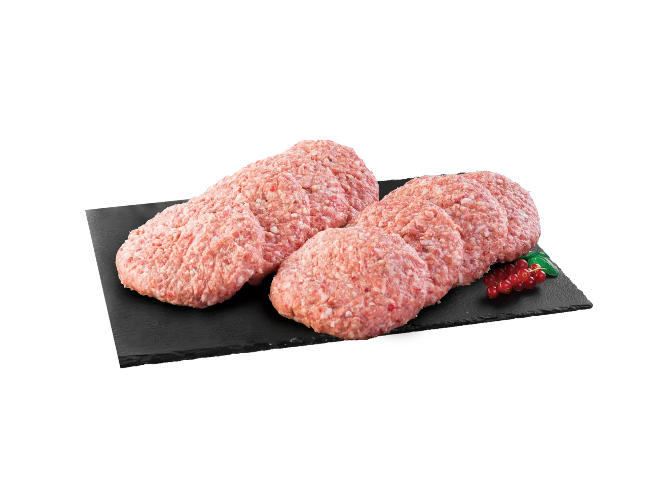 Sveže mleveno meso oblikovano u pljeskavice na crnoj dasci sa crvenim ribizlama.