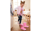 Petite fille en veste rose et bottes de pluie Pat' Patrouille.