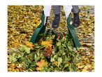 Person using leaf scoops to gather autumn leaves and garden debris.