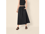 Saia midi preta Esmara, combinada com um top preto e sandálias.