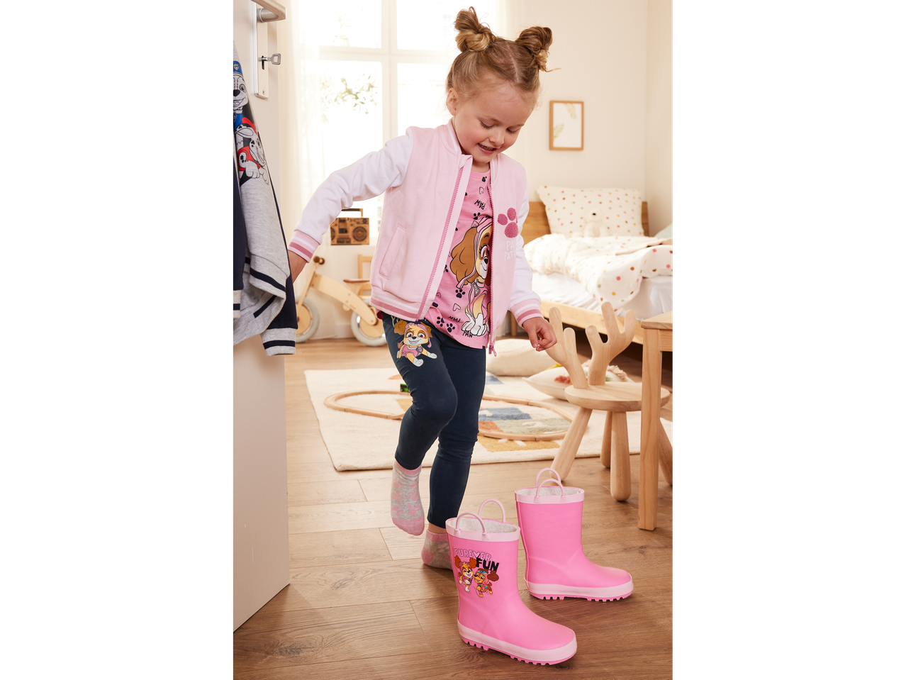 Petite fille en veste rose et bottes de pluie Pat' Patrouille.