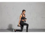 Woman doing squats with 5kg dumbbells.