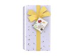 Gift box of Belgian chocolates with a gold ribbon and a tag featuring butterflies and leaves.