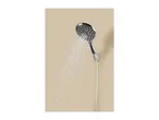 A chrome shower head spraying water against a light brown background.