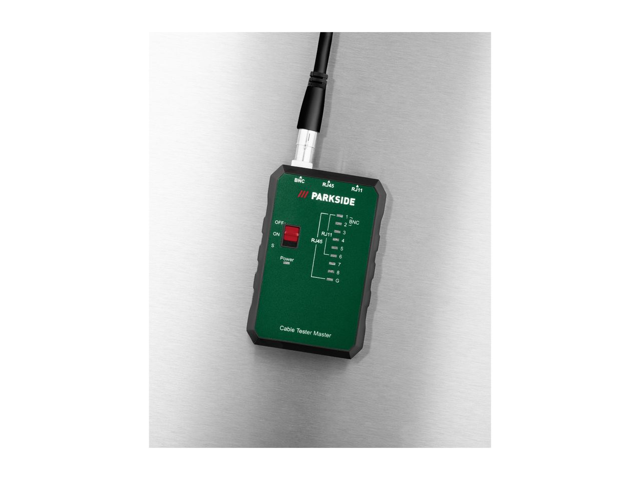 A Parkside cable tester master with BNC, RJ45, and RJ11 ports, and a power switch, on a metallic surface.