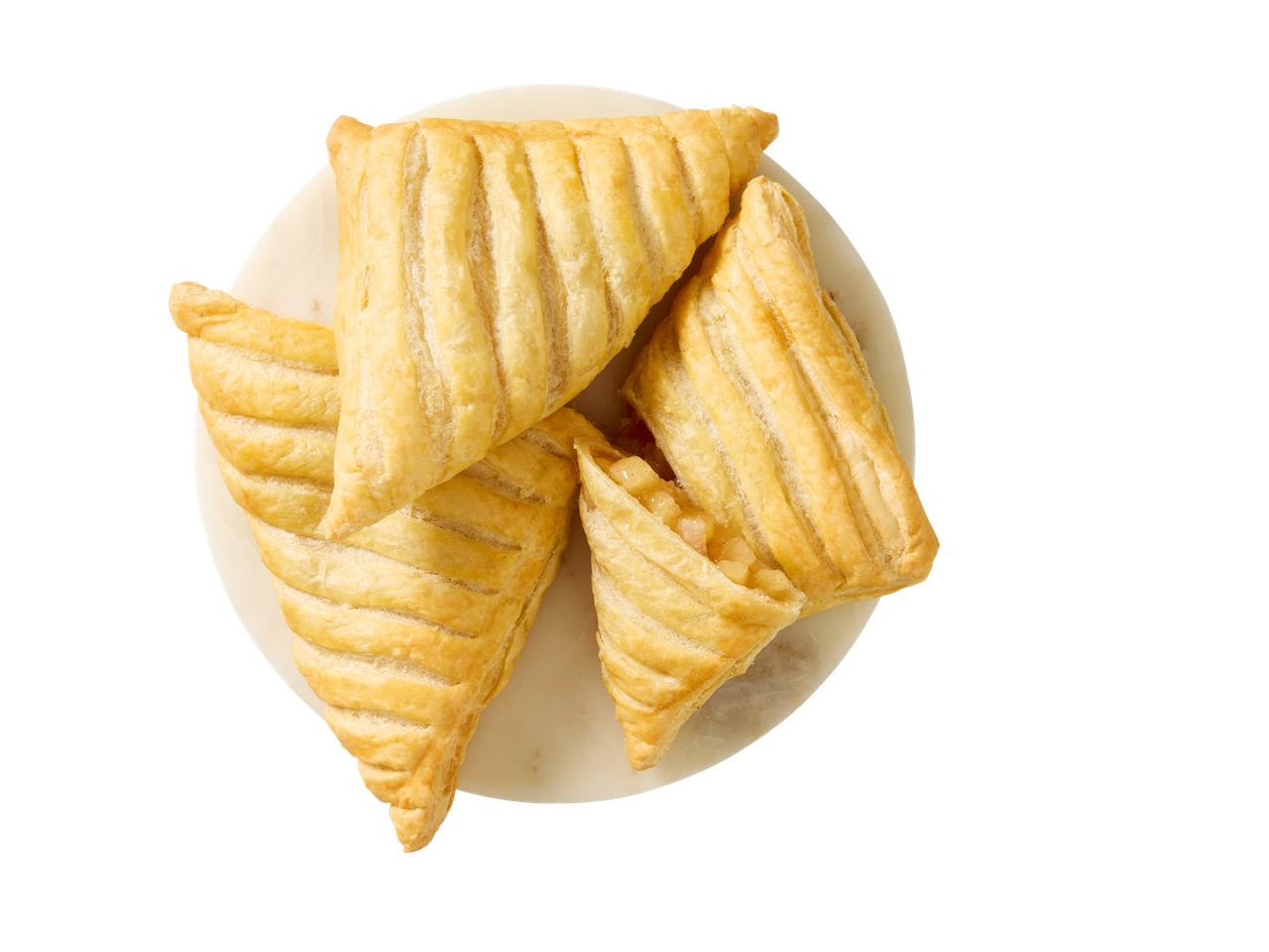 Patru appelflap aurii pe o farfurie albă, vedere de sus.