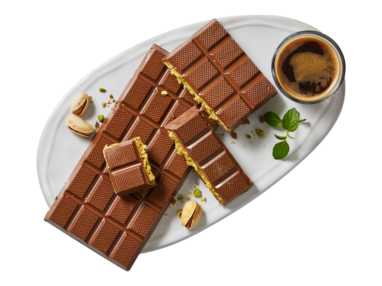 J.D. Gross Dubai Chocolate bars with pistachio filling, pistachios, and coffee on a white plate.