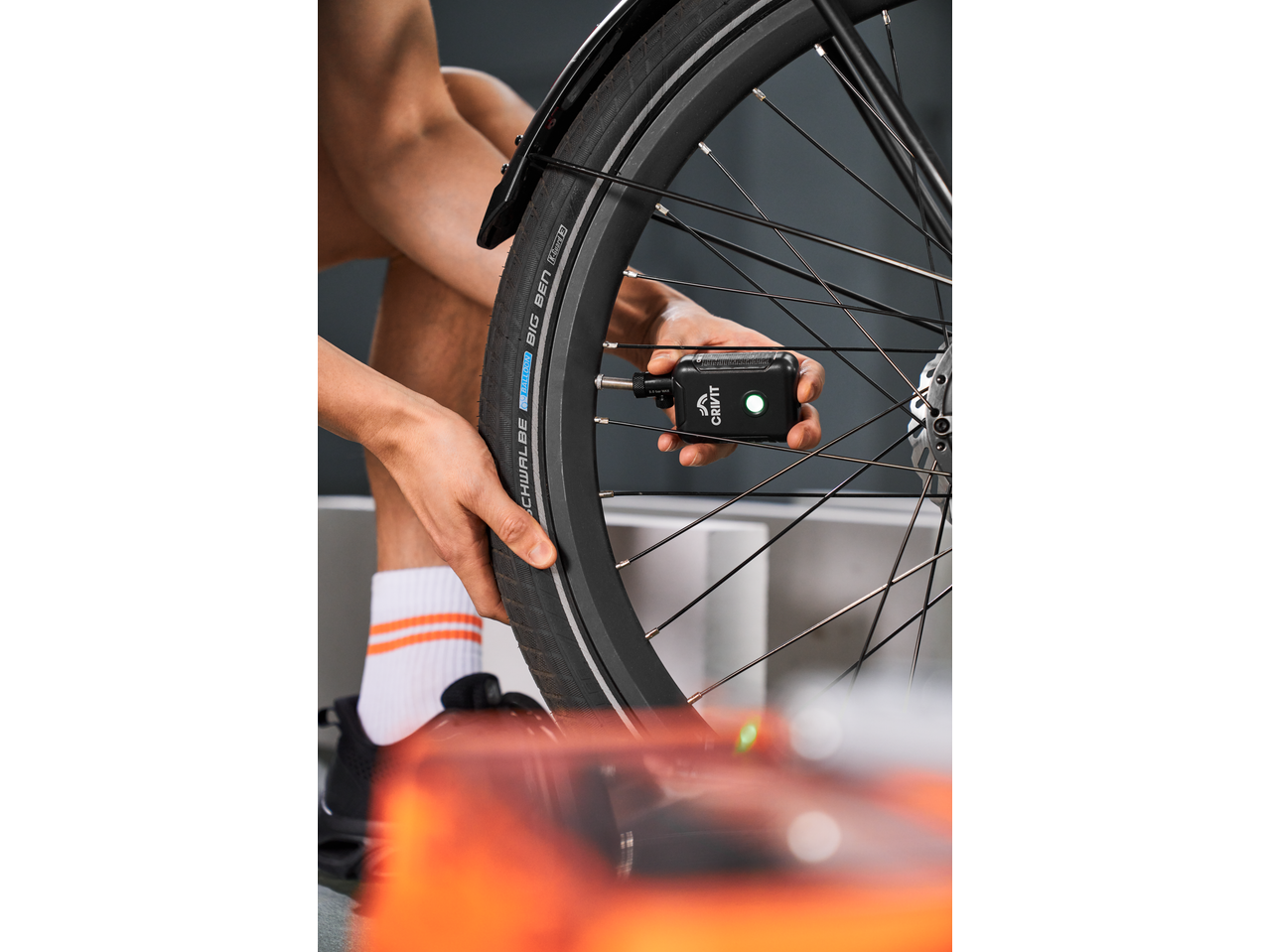 Persoană umflând o anvelopă de bicicletă cu un mini compresor de aer CRIVIT.