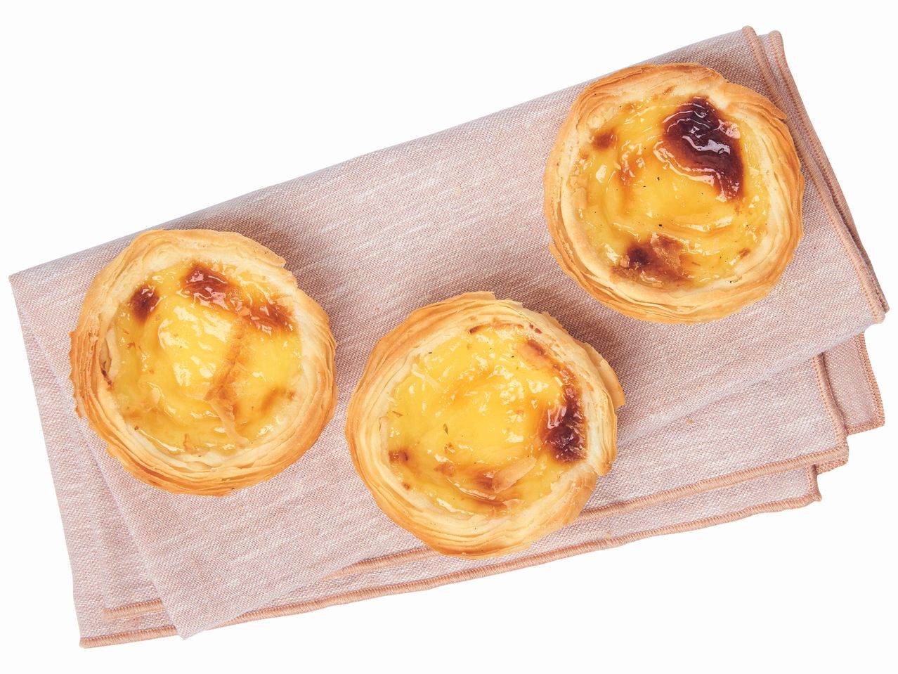 Trois pâtisseries portugaises aux œufs sur une serviette.