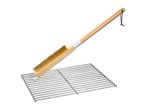 Grill brush with a long wooden handle and brass bristles, cleaning a metal grill grate.