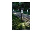 Solar path lights illuminating a garden walkway at dusk.