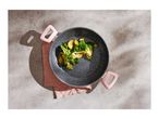 Overhead view of a pan with cooked vegetables on a concrete surface.