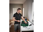 A man organizes Parkside tools in a green toolbox on a white countertop.