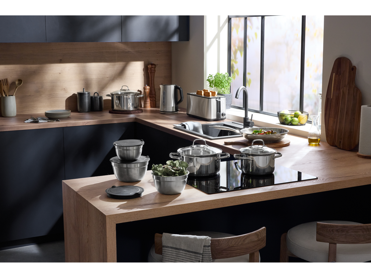 Cozinha moderna com chaleira SILVERCREST®, torradeira e várias panelas.