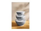 Stack of three grey mixing bowls with white lids on a wooden surface.