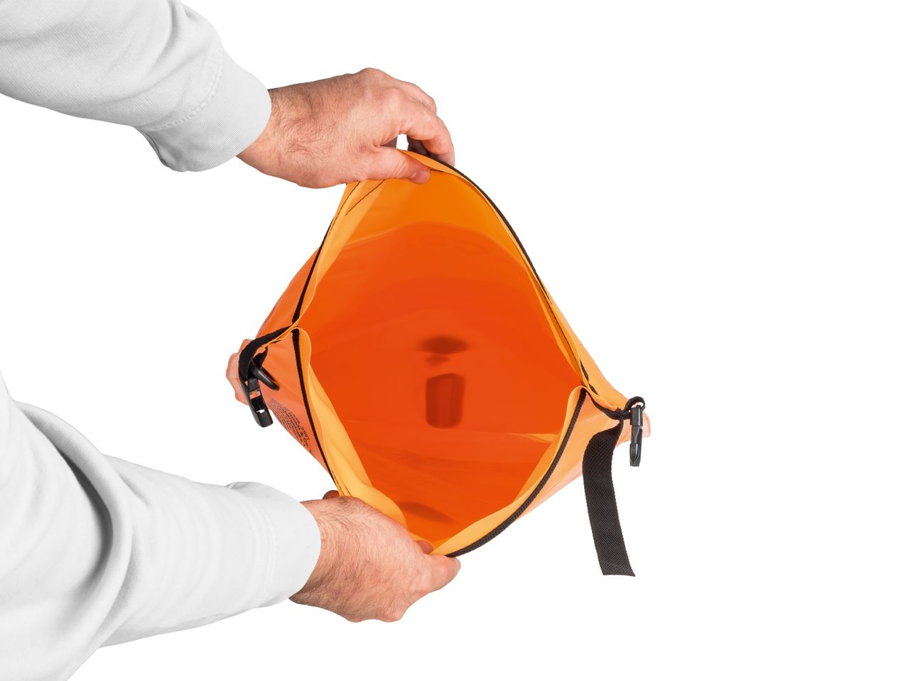 Hands holding open an orange dry bag, revealing its interior.