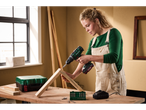 A woman uses a Parkside® 20V Cordless Drill Driver to assemble wooden pieces on a workbench.