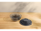 Conjunto de tigelas de vidro para misturar com tampas numa mesa de madeira.