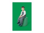 Smiling boy in grey waterproof overalls and blue boots, sitting on a green cylinder.