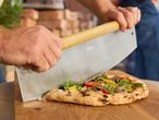 Wood-fired pizza sliced with a Grill Meister pizza cutter.