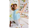 Criança brincando com números magnéticos em um quadro branco.