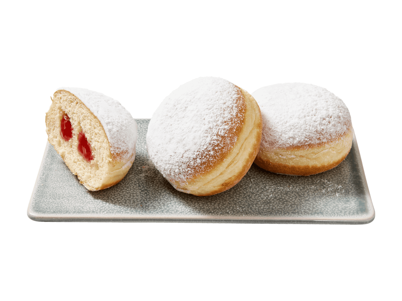 Trois beignets, deux entiers et un coupé en deux avec de la confiture rouge, sur un plat gris.