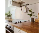 Kitchen with LIVARNO home self-adhesive wall tiles, wooden countertop, and induction hob.