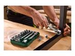 Man assembling furniture with a socket wrench set on a wooden table.
