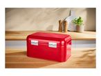 Red metal bread bin on a wooden kitchen countertop.