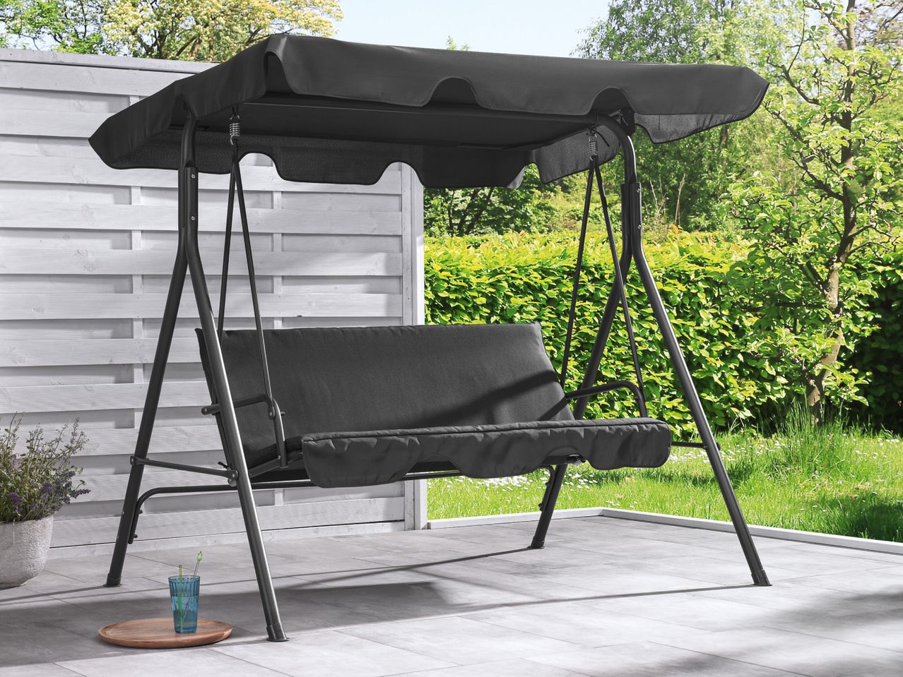 A black two-seater garden swing with a canopy.