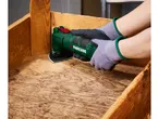 Una persona che leviga una cassa di legno con un utensile multifunzione.