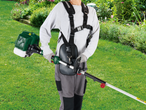 Person using a PARKSIDE® 4-in-1 Petrol Multi Tool with harness in a garden.
