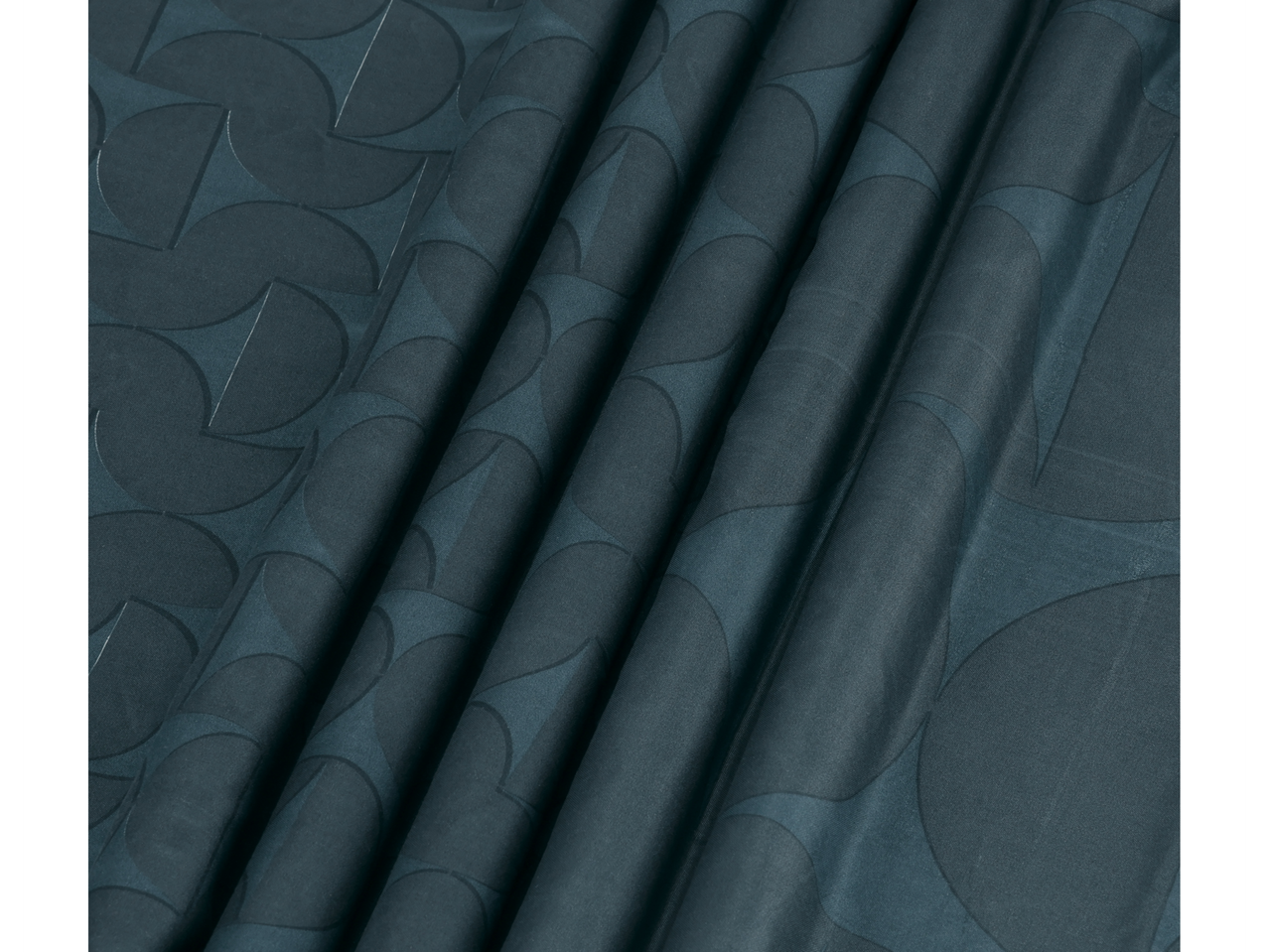 Donkergroene stof met een geometrisch patroon van halve manen en cirkels.