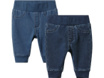 Två par blåa babyjeans med resår i midjan och muddar vid anklarna.
