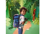 Criança sorridente com uma mochila azul numa selva de papel.