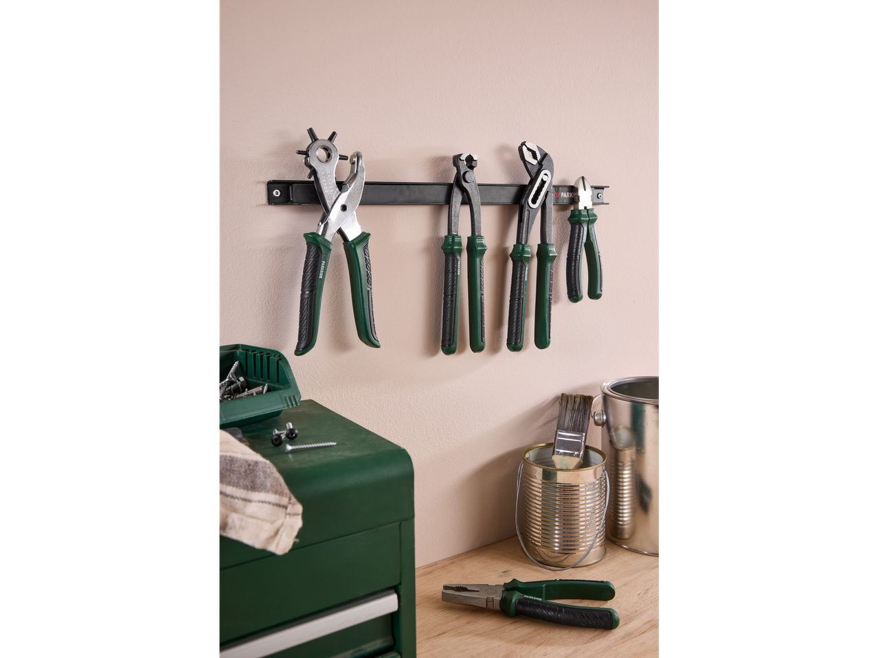 Parkside tools, including pliers and hole punches, hanging on a wall in a workshop setting.