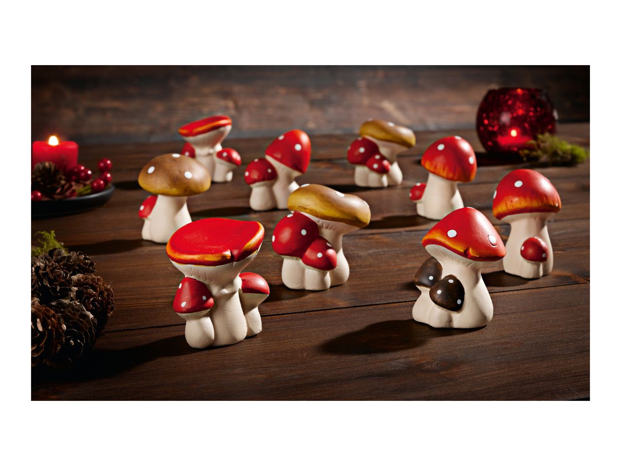 Mushroom figurines and candles on a wooden surface.