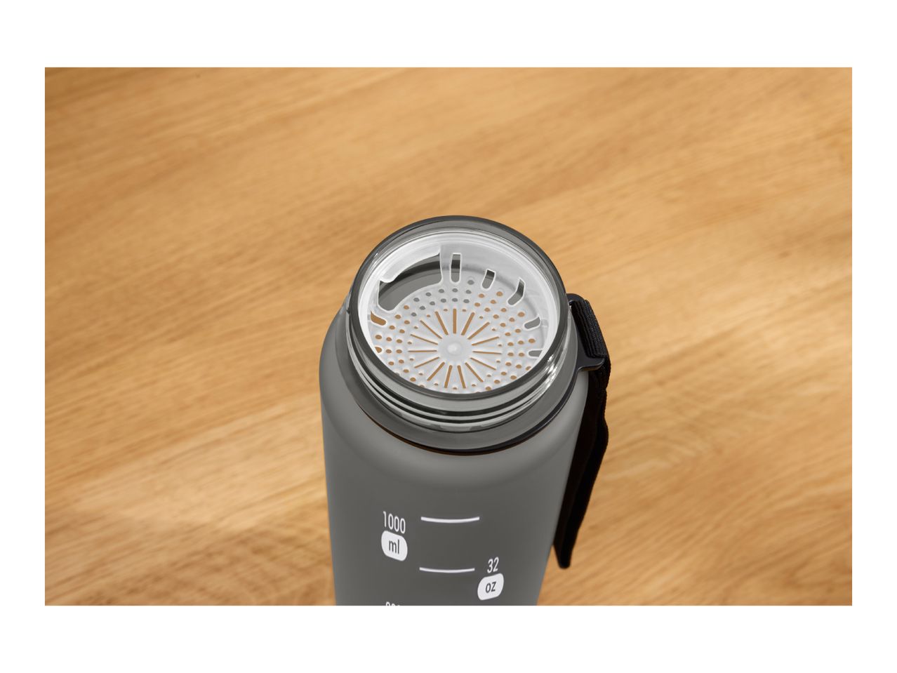 Top-down view of a grey water bottle with a white strainer and measurement markings.