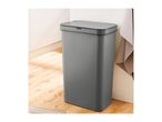 A grey, touch-free Brabantia trash can sits in a modern kitchen.