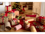 Crelando® reversible wrapping paper and gifts on a table with a Christmas tree.