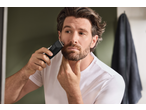 Man using a Cien BEAUTY Hair & Beard Trimmer to trim his beard in a bathroom.