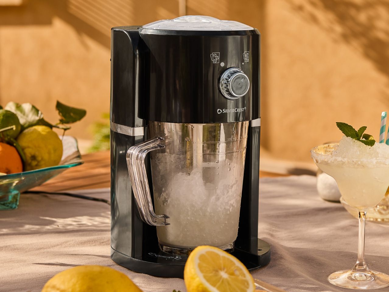 Retro-style electric drink mixer on a table with lemons and a cocktail.