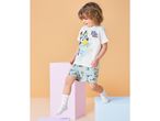 Toddler boy in white short-sleeved pajamas with a blue dog print and text 